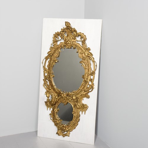 A Large Carved And Gilded Rococo Mirror