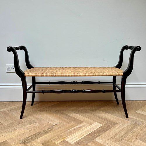 An Ebonised Wood And Rattan Bench