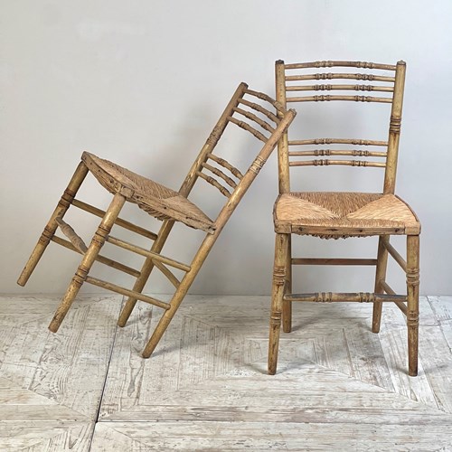 A Pair Of Painted Regency Faux Bamboo And Rush Seat Chairs