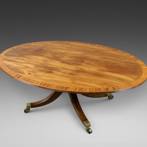 A Large Oval Flame Mahogany Coffee Table