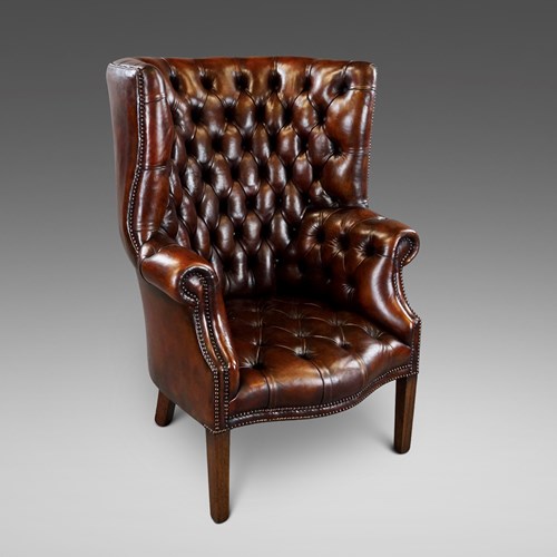 A Deep Buttoned Chestnut Brown Barrel Back Wing Chair