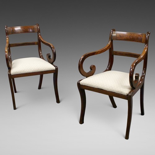 A pair of Regency mahogany brass inlaid arm chairs