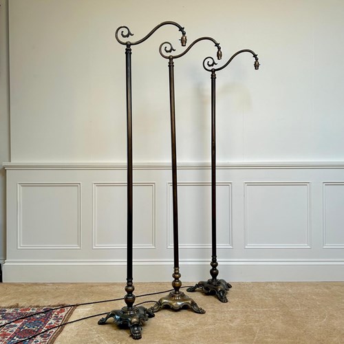 A Set Of 3 Patinated Brass Floor Lamps
